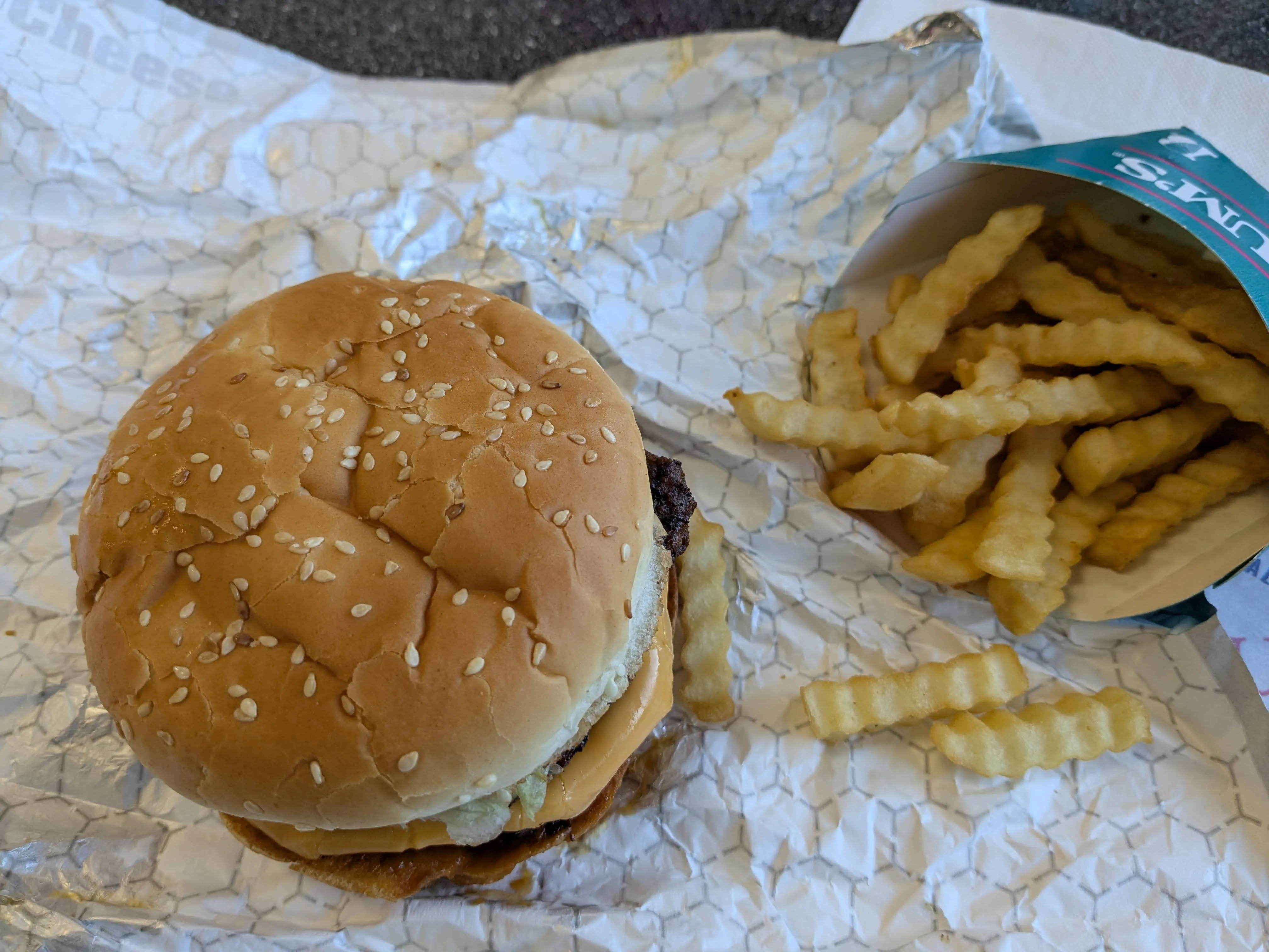 A burger and crinkle fries on a tray